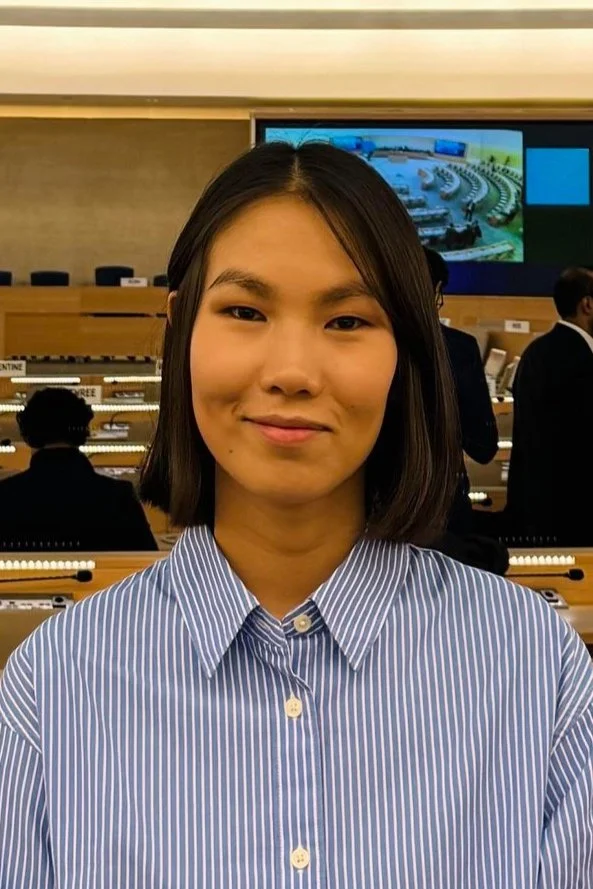 Young person in a formal meeting room.