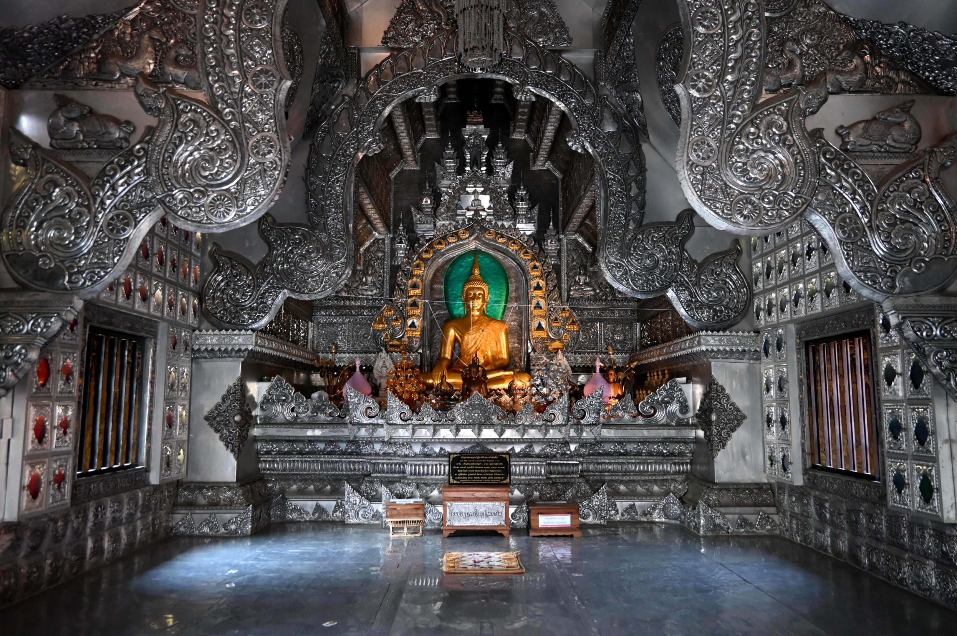 Ornate Buddha statue in a detailed temple alcove.