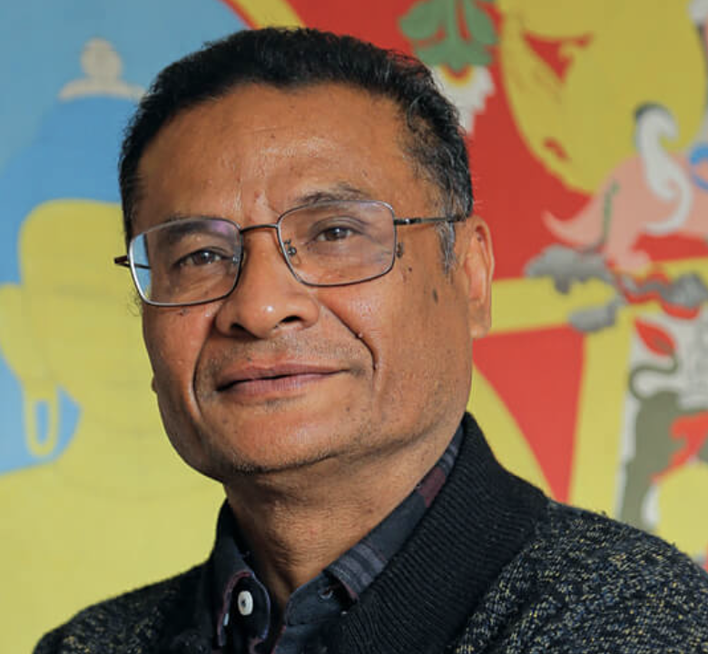 Man with glasses, colorful background mural.
