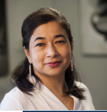 Smiling person wearing white shirt and earrings.