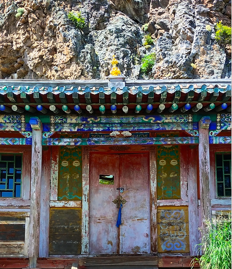 Colorful traditional building with intricate designs in a rocky landscape.