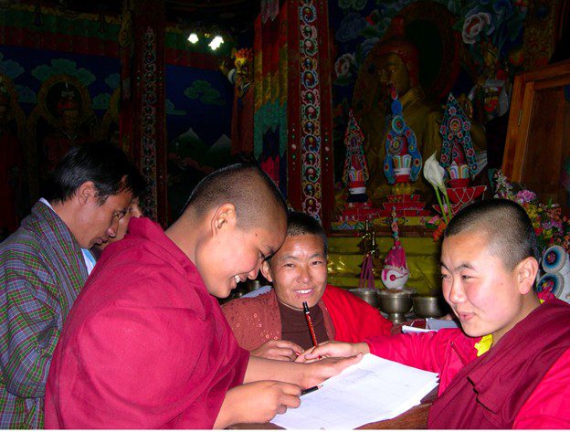 Young monks reading and studying together in a colorful temple.