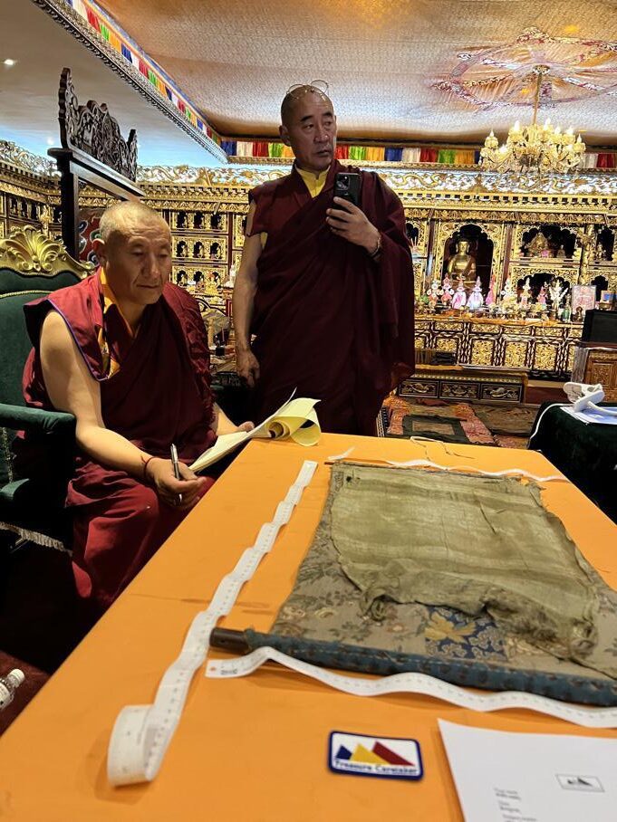 Monks examining an ancient manuscript in a temple.