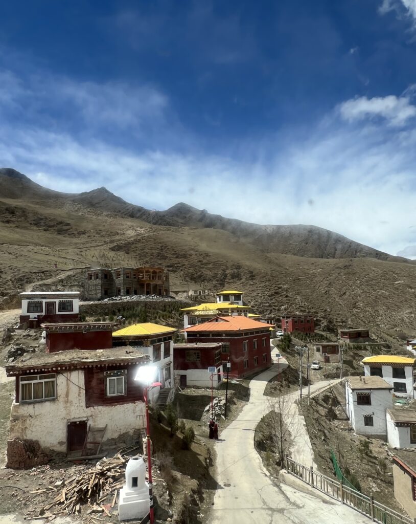 Mountain village with colorful roofs under a blue sky.