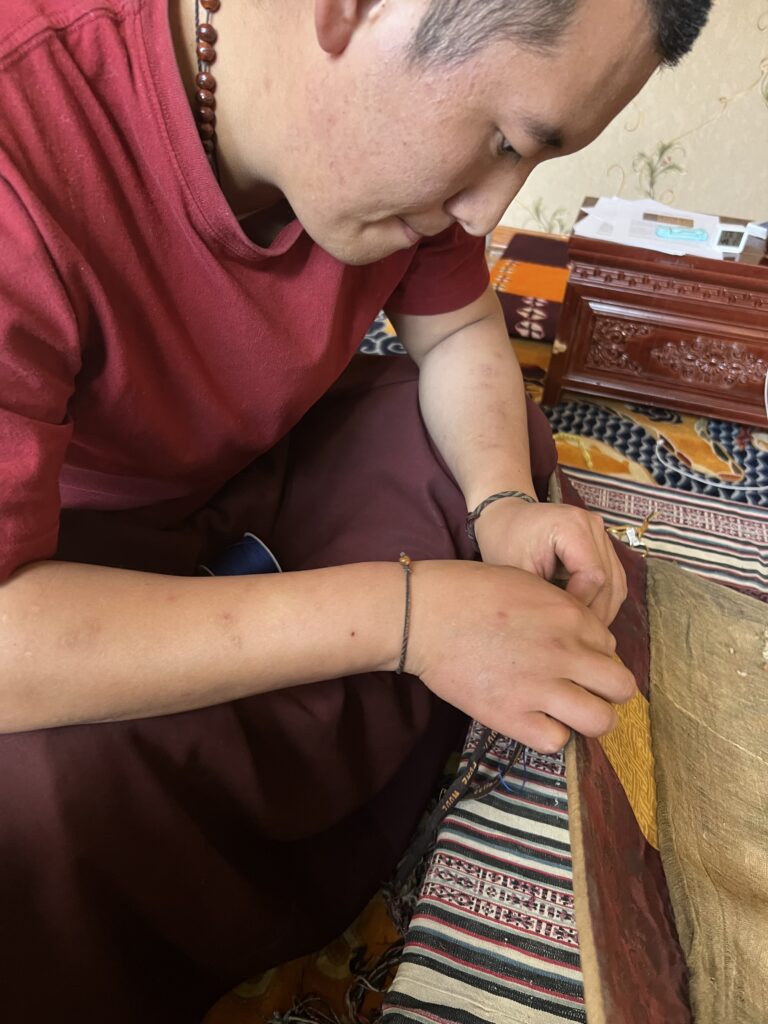 Person preparing traditional food with hands on a woven mat.