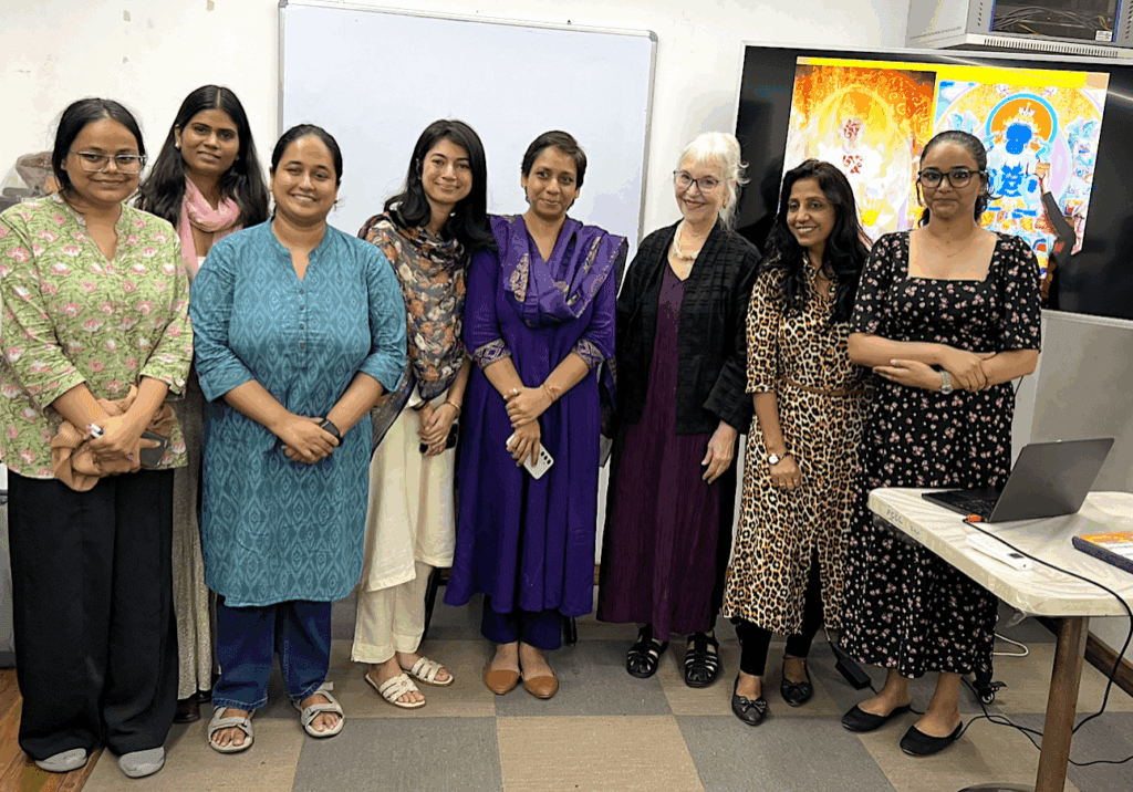 Group of women standing together in a room, smiling at the camera.