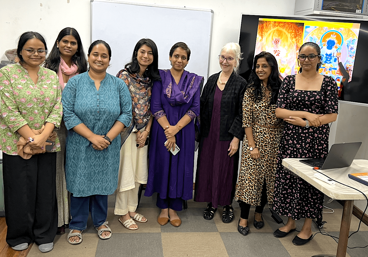 Group of women standing together in a room, smiling at the camera.