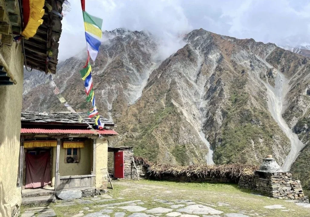 Mountain village with prayer flags and house.