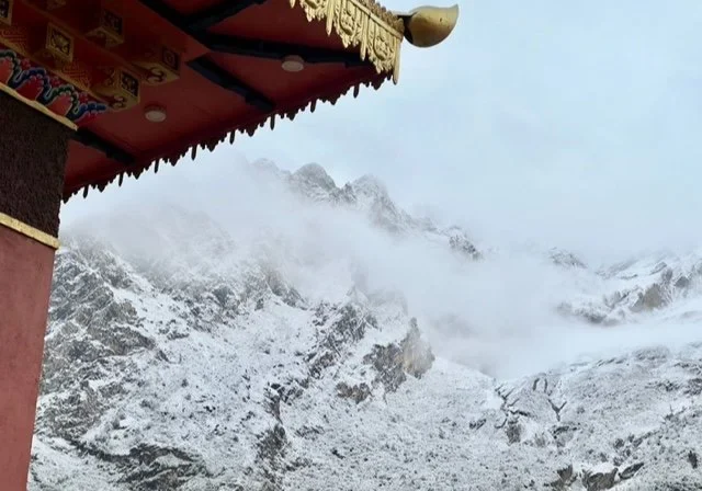 Temple roof and snow-covered mountains.
