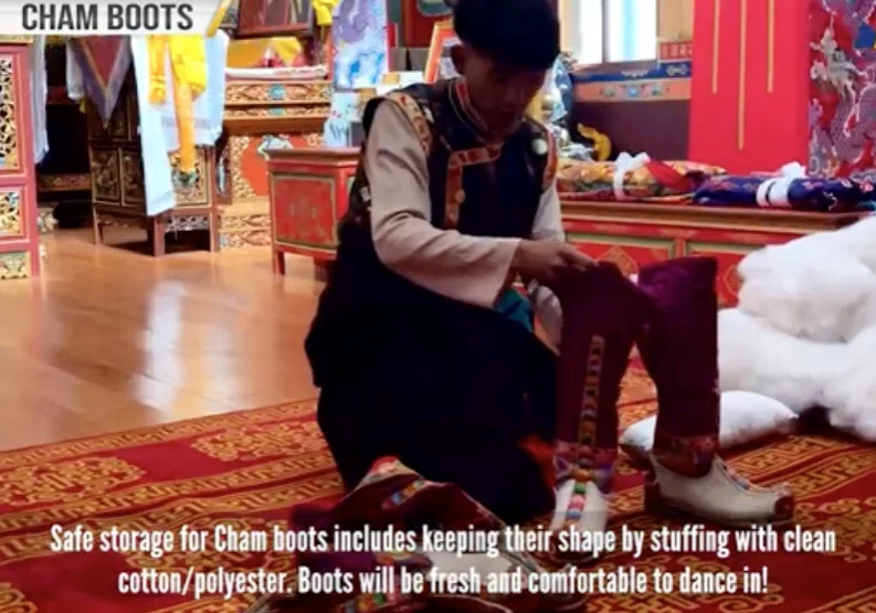 Person preparing Cham boots in ornate room.